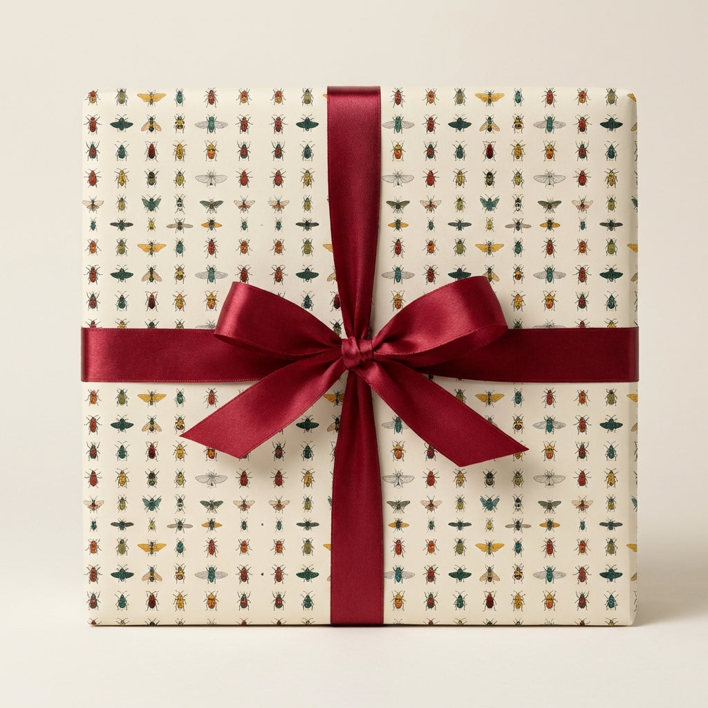 Square gift wrapped in insect-themed wrapping paper with burgundy ribbon.