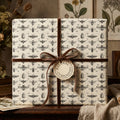 Gift wrapped in insect-themed wrapping paper with brown velvet ribbon and "Natural Curiosities" tag.