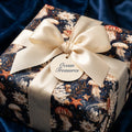 Ocean themed luxury wrapping paper featuring a jellyfish pattern and cream satin bow by Wrapped Studios.