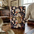 Vintage jellyfish wrapping paper by Wrapped Studios on a gift box with gold twine on a wooden table.