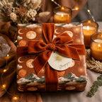 Boho celestial wrapping paper with moon patterns and a terracotta velvet bow, by Wrapped Studios.