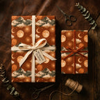 Celestial wrapping paper with a rust moon and mountain pattern on gifts by Wrapped Studios.