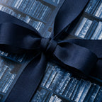 Luxury library book wrapping paper in navy blue with a matching grosgrain ribbon bow by Wrapped Studios.