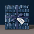Vintage library bookshelf wrapping paper with a purple ribbon, literary gift wrap by Wrapped Studios.