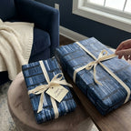 Blue book wrapping paper with library bookshelf pattern and cream bow by Wrapped Studios.