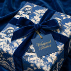 Luxury blue Christmas wrapping paper with a Madonna and Child pattern and velvet bow by Wrapped Studios.