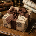 Vintage map wrapping paper on a gift box with a rustic, frayed brown ribbon by Wrapped Studios.