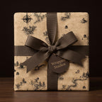 Vintage map wrapping paper on a gift box with a brown ribbon bow by Wrapped Studios.
