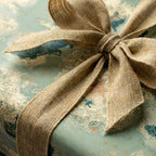 Vintage map wrapping paper tied with a rustic burlap bow, luxury gift wrap by Wrapped Studios.