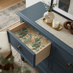 Vintage landscape wrapping paper by Wrapped Studios used as a decorative drawer liner in a blue dresser.
