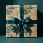 Vintage travel map wrapping paper on a luxury gift box with a teal satin bow, by Wrapped Studios.