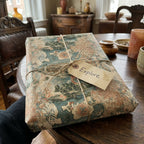 Vintage map wrapping paper tied with rustic twine and an 'Explore' tag by Wrapped Studios.