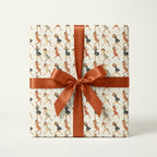 Gift wrapped in vintage-style wrapping paper with a dancing women pattern and tied with a copper-colored satin ribbon.