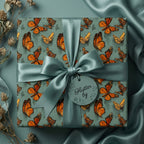 Elegant butterfly wrapping paper with teal satin bow, perfect for birthday gifts or special occasions.
