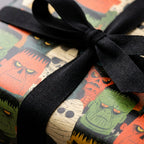 Vintage monster Halloween wrapping paper with a black ribbon bow by Wrapped Studios.
