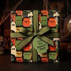 Retro monster Halloween wrapping paper with a green ribbon bow by Wrapped Studios.