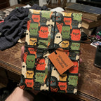 Retro monster Halloween wrapping paper on a gift with black string and a Wrapped Studios tag.