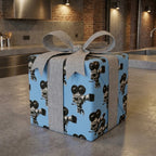 Retro movie camera wrapping paper on a light blue gift box with a grey bow by Wrapped Studios.