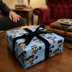 Vintage movie camera wrapping paper in blue with a black velvet bow by Wrapped Studios.