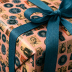 Pink retro movie wrapping paper with classic Hollywood prints and teal ribbon from Wrapped Studios.