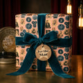 Vintage movie wrapping paper with a teal velvet bow and "For the Star" tag by Wrapped Studios.