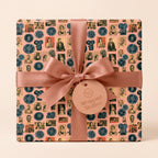 Vintage Hollywood wrapping paper with retro cinema film reels and pink satin bow by Wrapped Studios.