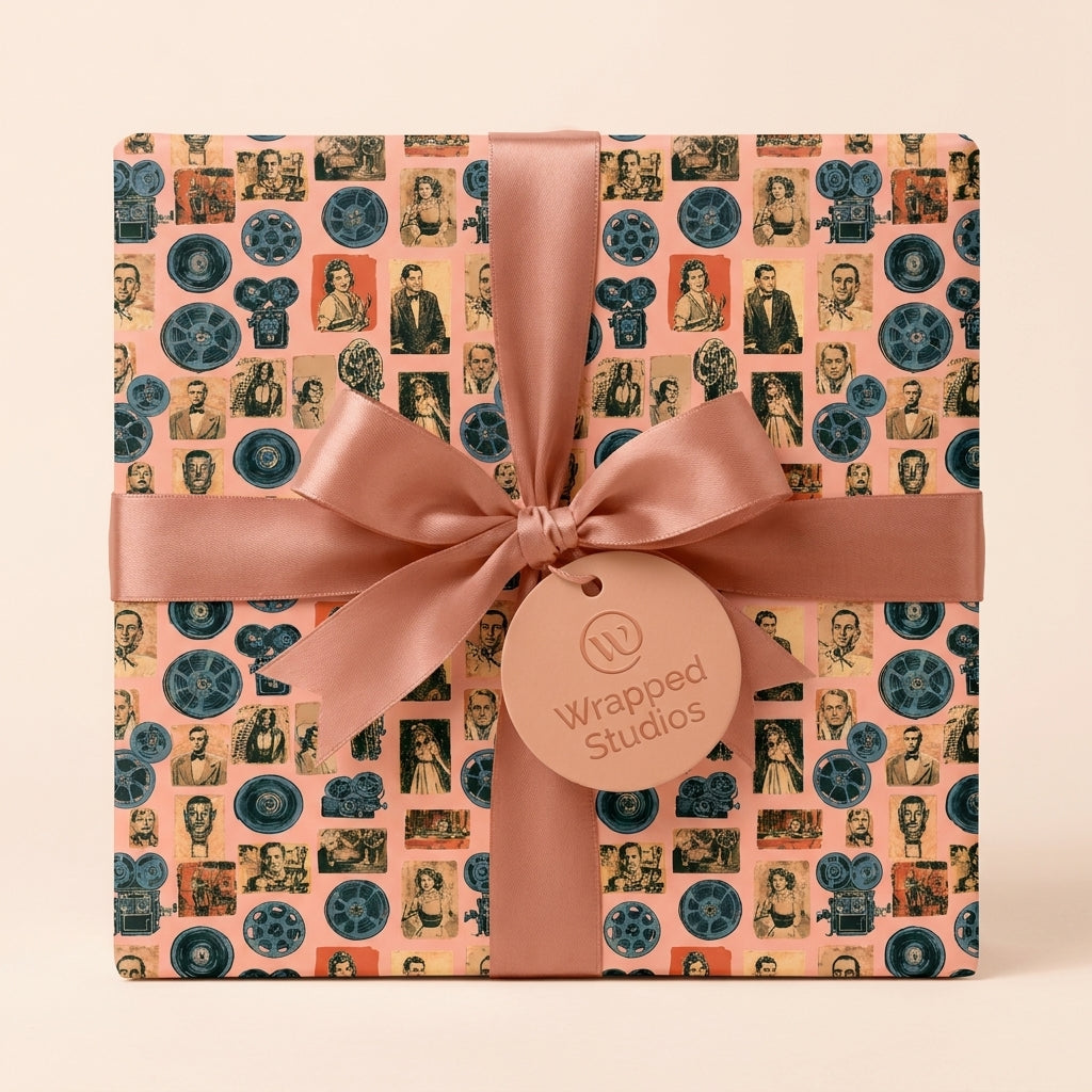 Vintage Hollywood wrapping paper with retro cinema film reels and pink satin bow by Wrapped Studios.