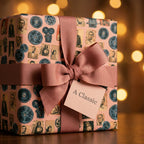 Retro cinema wrapping paper in dusty pink with a matching ribbon bow by Wrapped Studios.