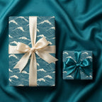 Teal ocean wave wrapping paper with luxury satin bows on a silk background by Wrapped Studios.