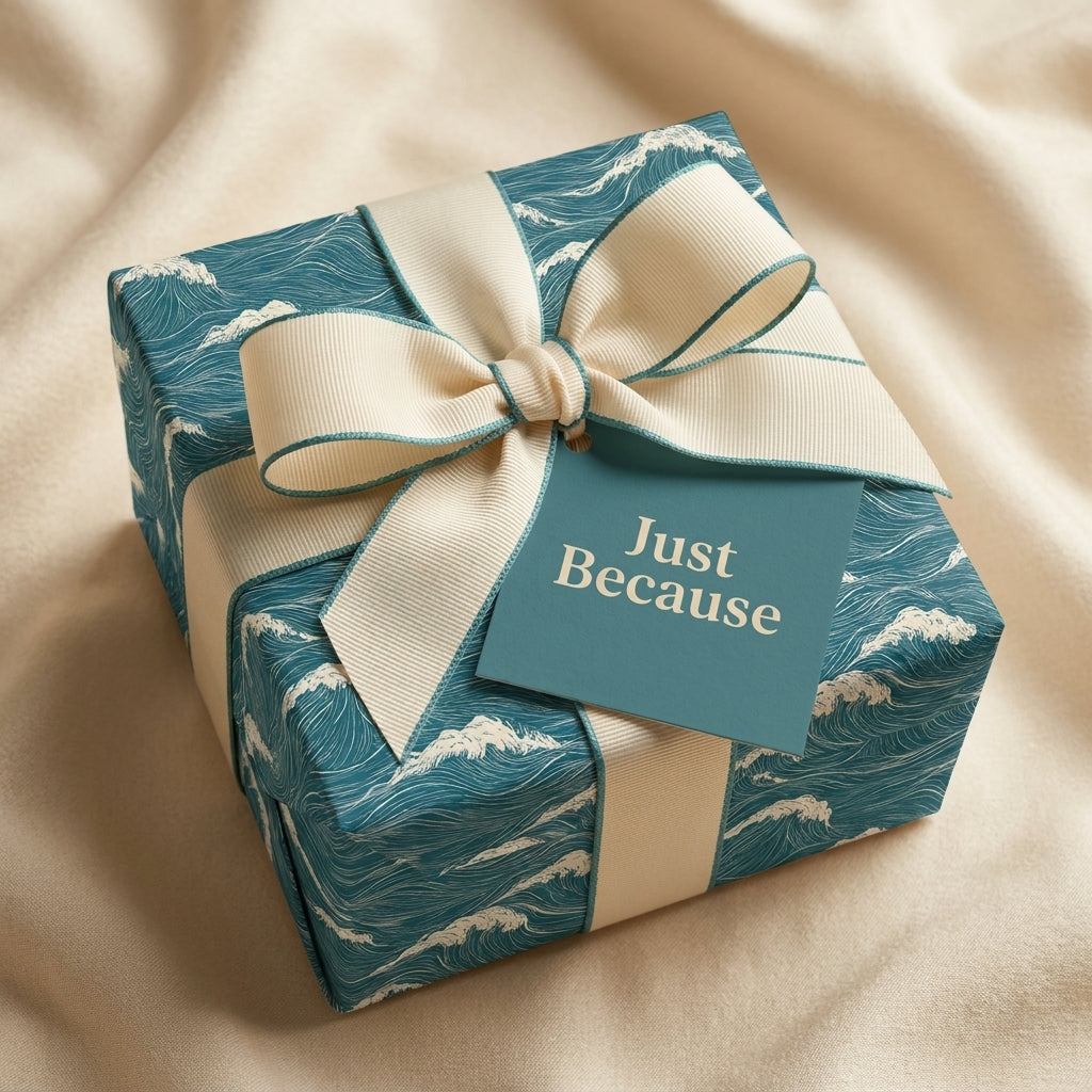 Teal ocean wave wrapping paper with cream ribbon and "Just Because" tag, luxury gift wrap by Wrapped Studios.