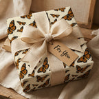 Elegant gift wrapped in butterfly wrapping paper with a burlap ribbon and "For You" tag.
