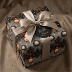 Luxury Christmas wrapping paper with vintage ornaments and a gold bow on a gift box by Wrapped Studios.