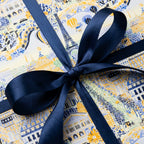 Paris illustrated luxury gift wrap in yellow and blue with a navy satin bow by Wrapped Studios.