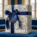 Parisian luxury gift wrap featuring Eiffel Tower pattern and navy blue ribbon by Wrapped Studios.