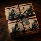 Vintage American flag wrapping paper on a gift box with a black cord bow and For Him tag by Wrapped Studios.