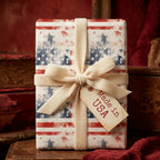 Patriotic wrapping paper with a vintage American flag design and cream velvet bow by Wrapped Studios.