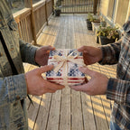 Patriotic American flag wrapping paper with a cream bow on a gift being exchanged, by Wrapped Studios.