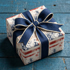 Vintage patriotic wrapping paper with an American flag print and navy blue bow, by Wrapped Studios.