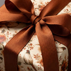 Vintage pheasant wrapping paper with a brown grosgrain ribbon bow on a luxury gift by Wrapped Studios.