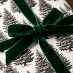 Elegant Christmas wrapping paper with a pine tree pattern and green velvet ribbon bow by Wrapped Studios.
