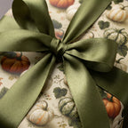 Rustic fall pumpkin wrapping paper with an olive green satin ribbon bow by Wrapped Studios.