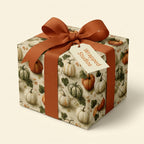 Fall pumpkin wrapping paper on a gift box with a burnt orange ribbon, by Wrapped Studios.