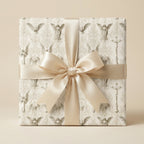 Religious wrapping paper with vintage angels and a champagne satin bow by Wrapped Studios.