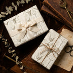 Vintage religious wrapping paper with angels on gift boxes with cream ribbon, by Wrapped Studios.