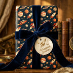 Vintage outer space wrapping paper with planets and rockets, tied with a navy velvet bow by Wrapped Studios.