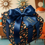 Retro outer space wrapping paper by Wrapped Studios, featuring rockets and planets with a navy blue satin bow.