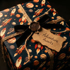 Outer space wrapping paper with retro rockets, planets, and a black velvet ribbon by Wrapped Studios.