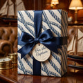 Nautical wrapping paper with blue rope pattern and navy satin bow by Wrapped Studios.
