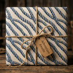 Nautical rope wrapping paper on a rustic gift box with an Adventure Awaits tag by Wrapped Studios.