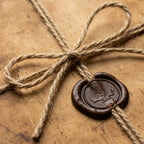 Rustic kraft wrapping paper with jute twine bow and dark wax seal. Natural gift wrap by Wrapped Studios.